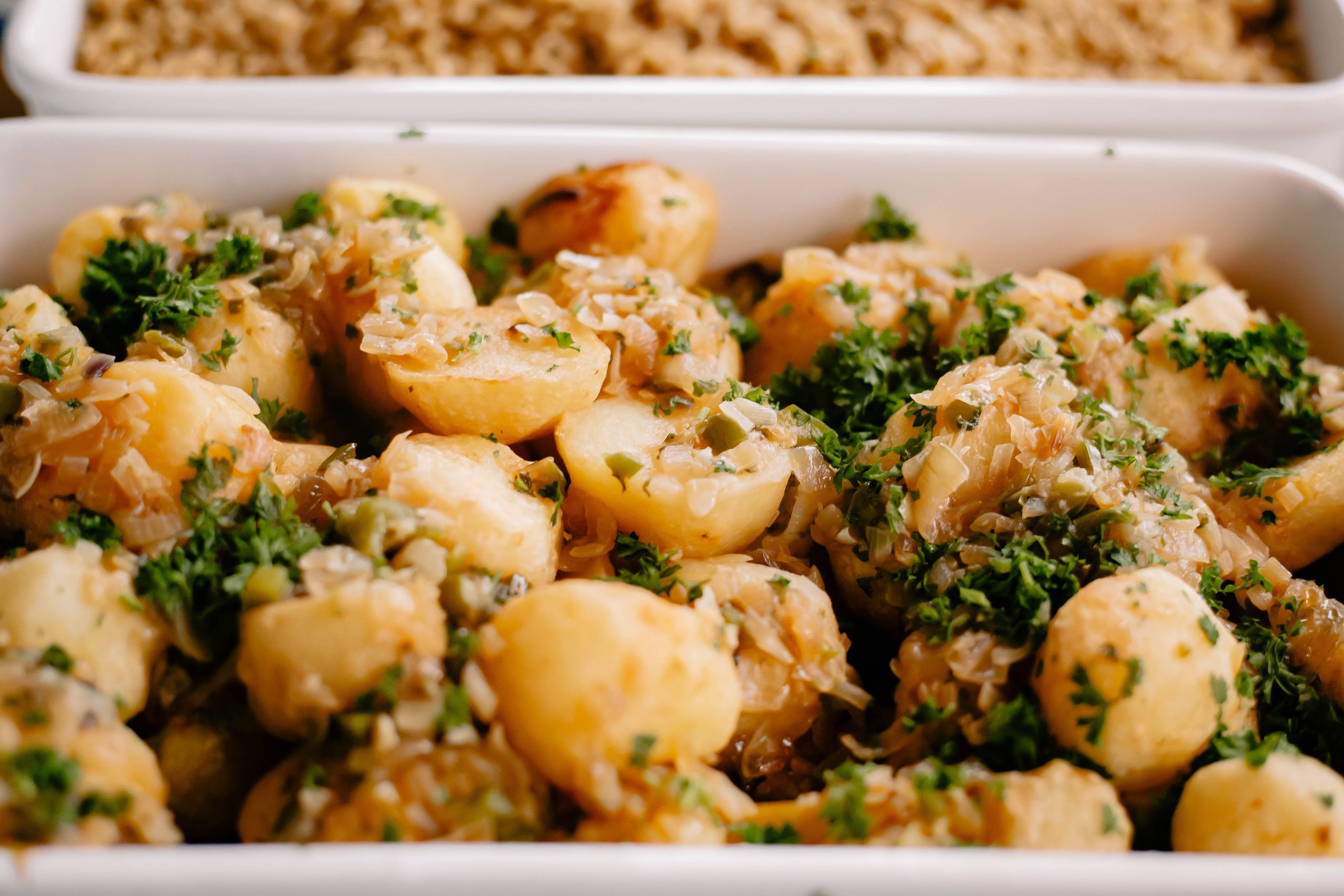A delicious close-up of seasoned potatoes garnished with fresh parsley, perfect for a hearty meal.